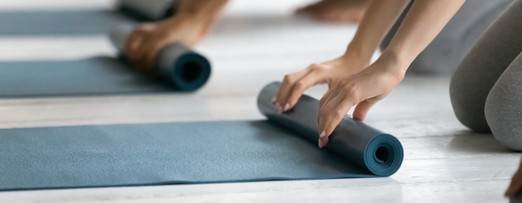 people rolling up yoga mats